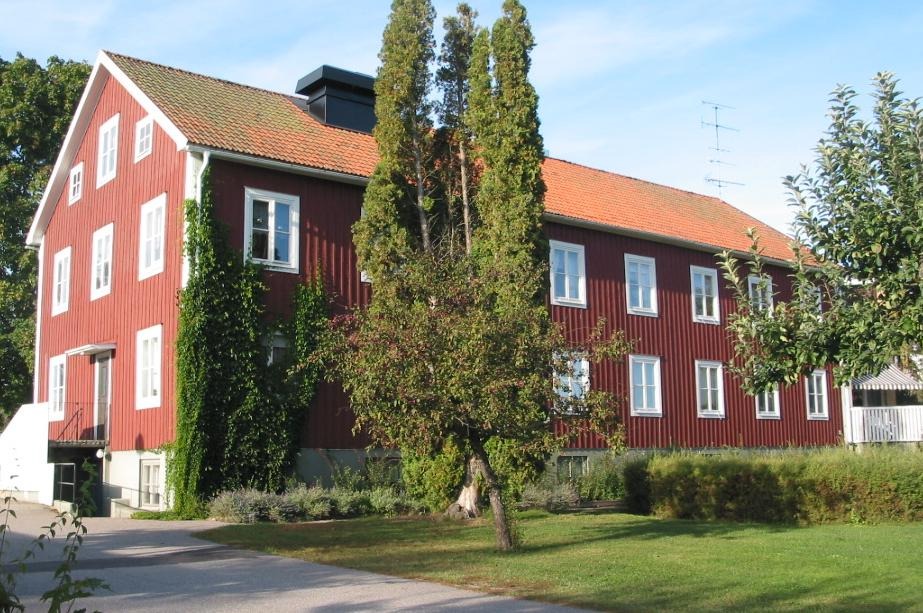 Tallgårdens äldreboende i Östervåla som är en faluröd byggnad. Här i sommargrönska.