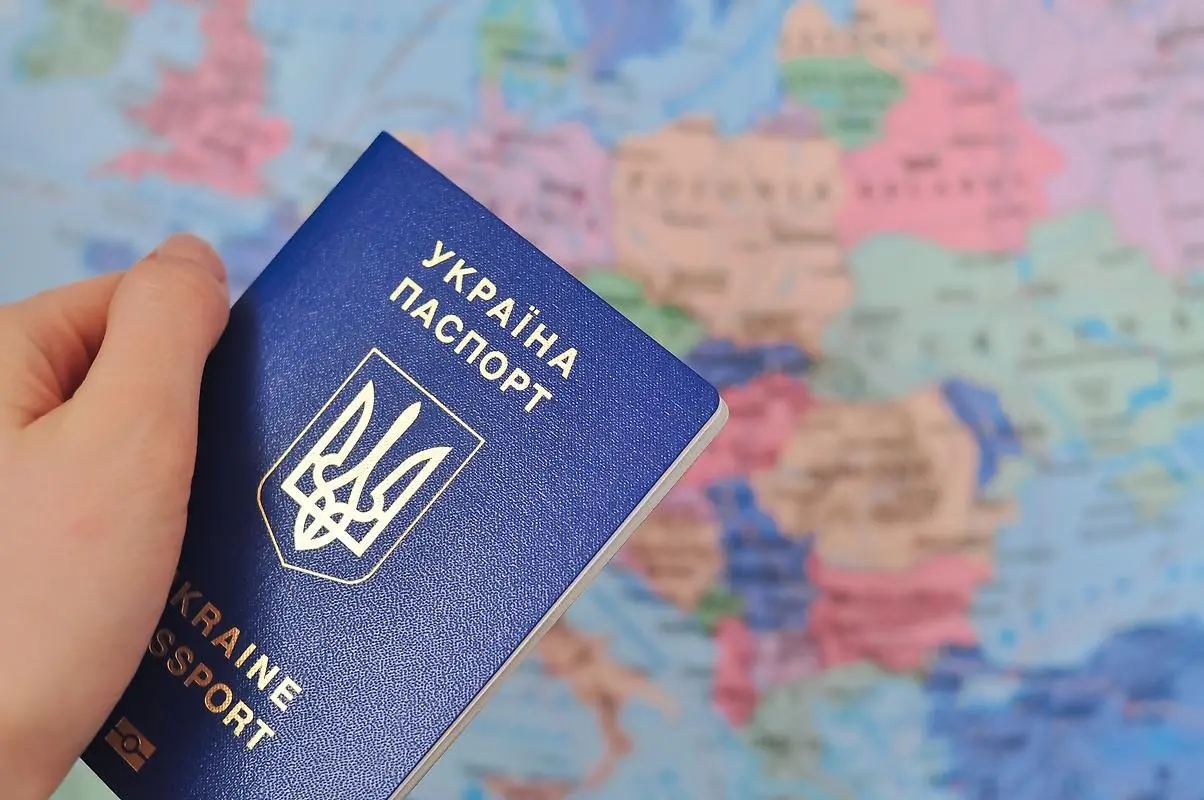 Ukrainskt pass framför en världskarta