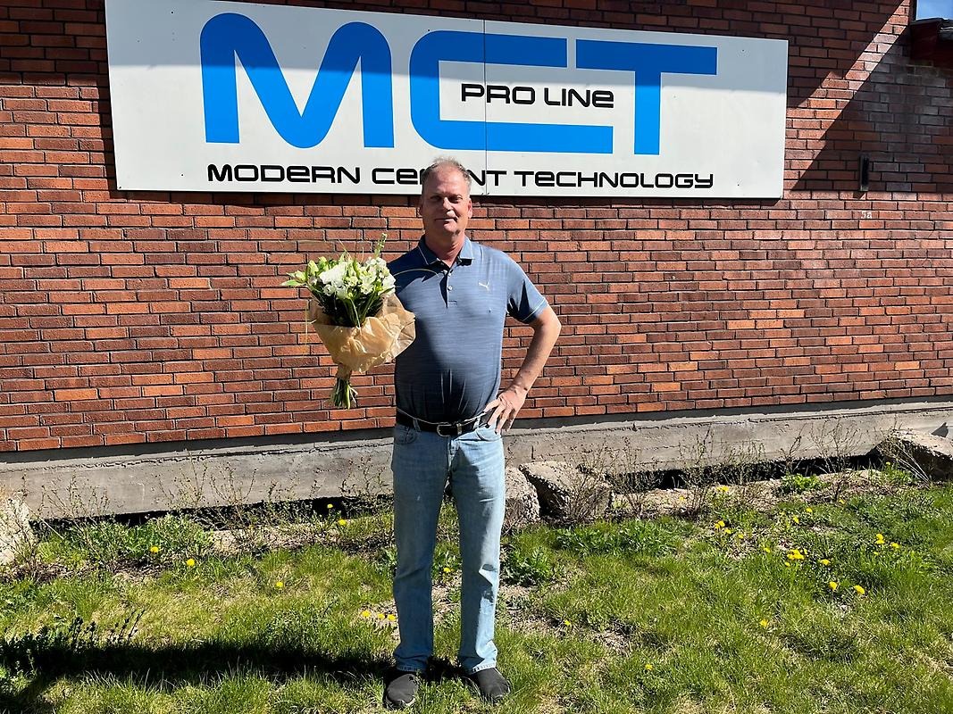 Michael Bjerkliden står framför sitt företag med blommor i handen.