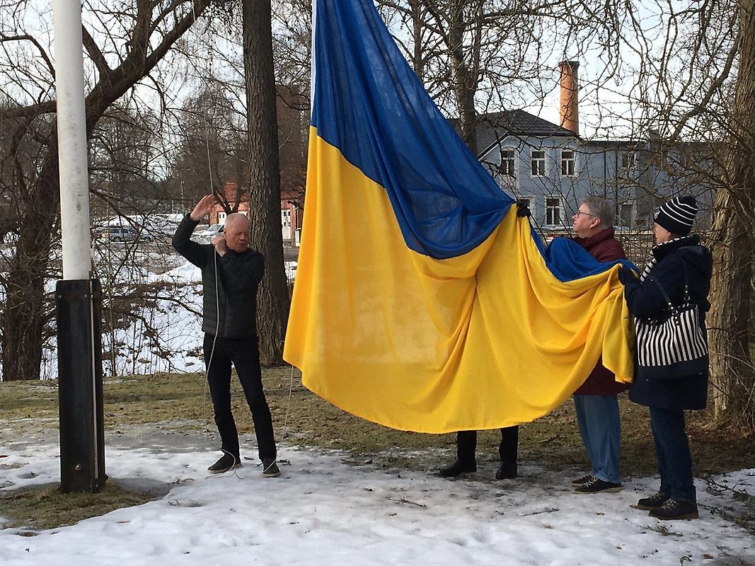 Tomas Engström hissar den ukrainska flaggan tillsammans med kommunsstyrelsens presidium.
