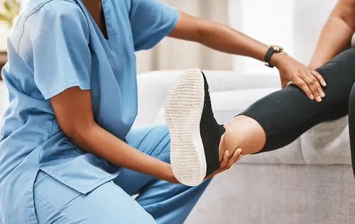 Fysioterapeut känner på och hjälper vårdtagare att sträcka ut sitt ben