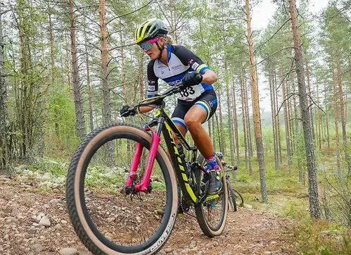 Kvinna cyklar i skogen på mountainbike