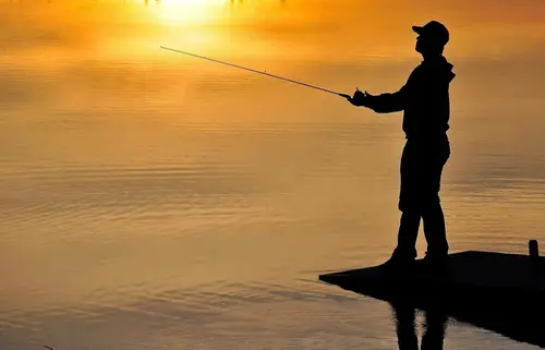 Man fiskar i solnedgång